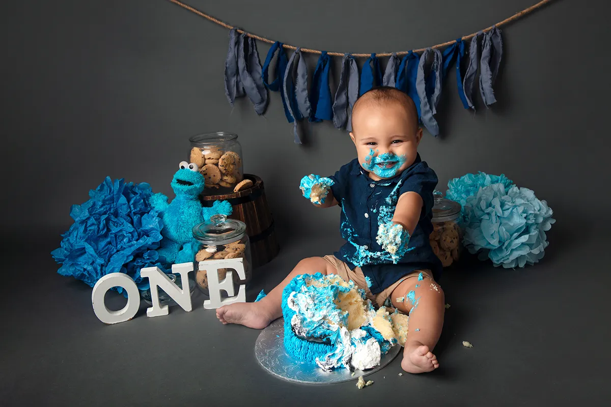 Baby enjoying cake smash session during first birthday photography in Auckland