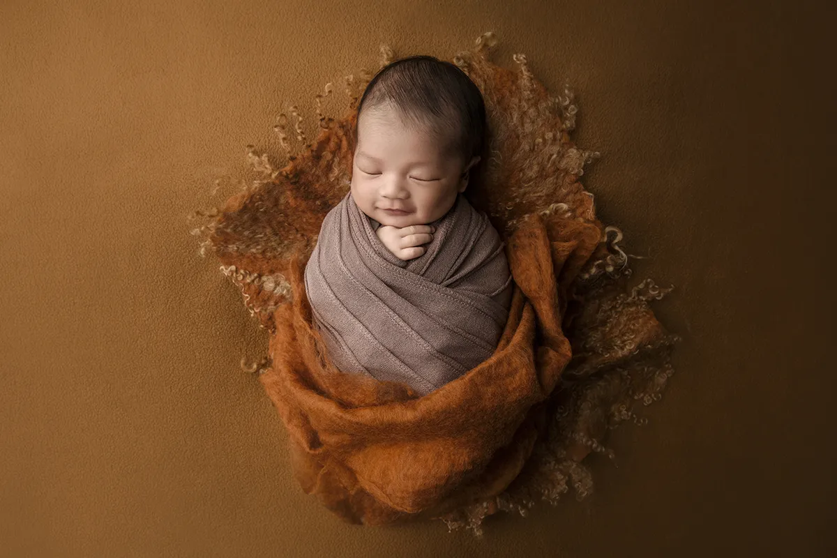 Wrapped newborn baby photographed at Photo Hive studio in Auckland